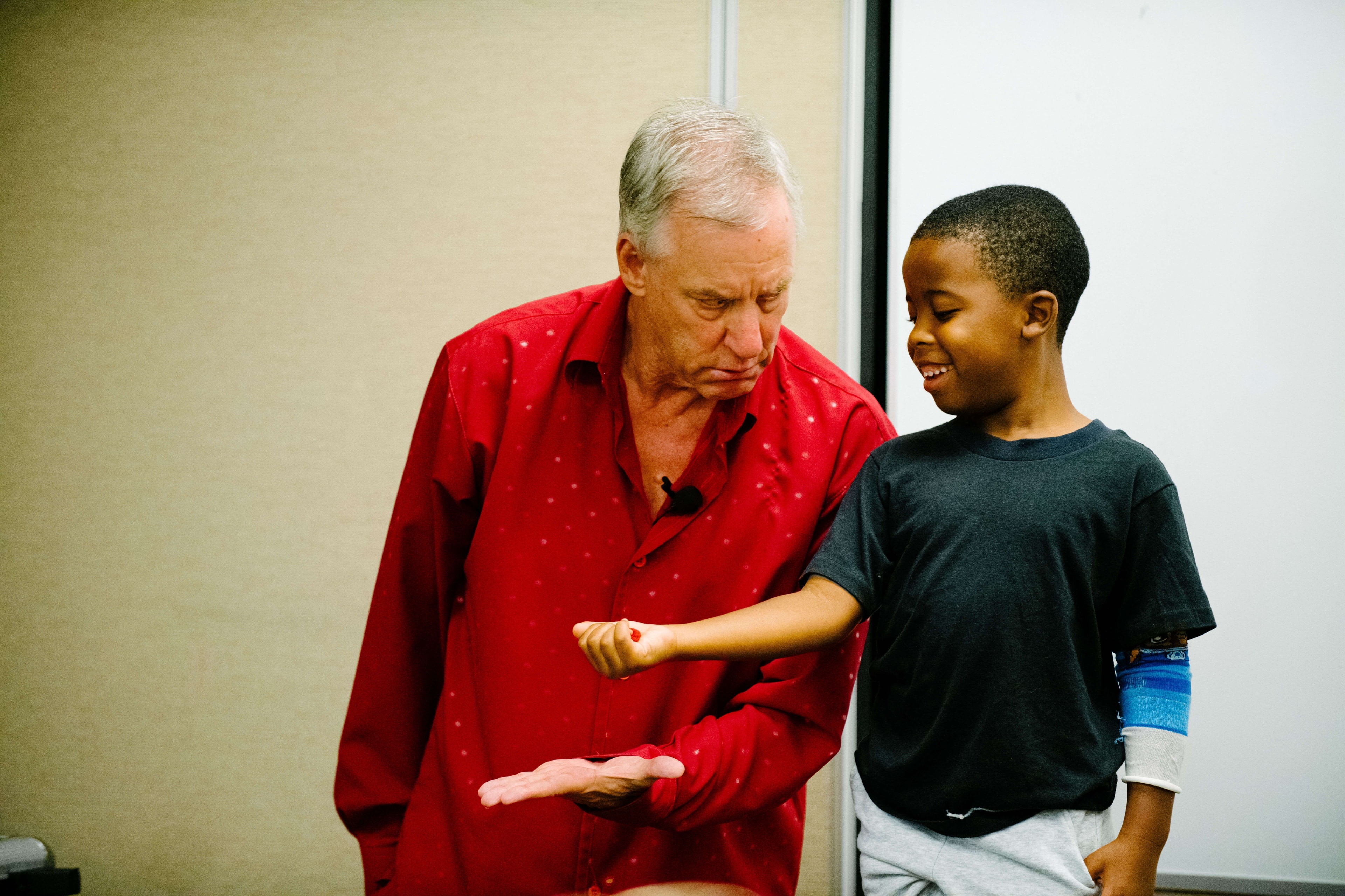Timothy Pitch performing magic with a child volunteer